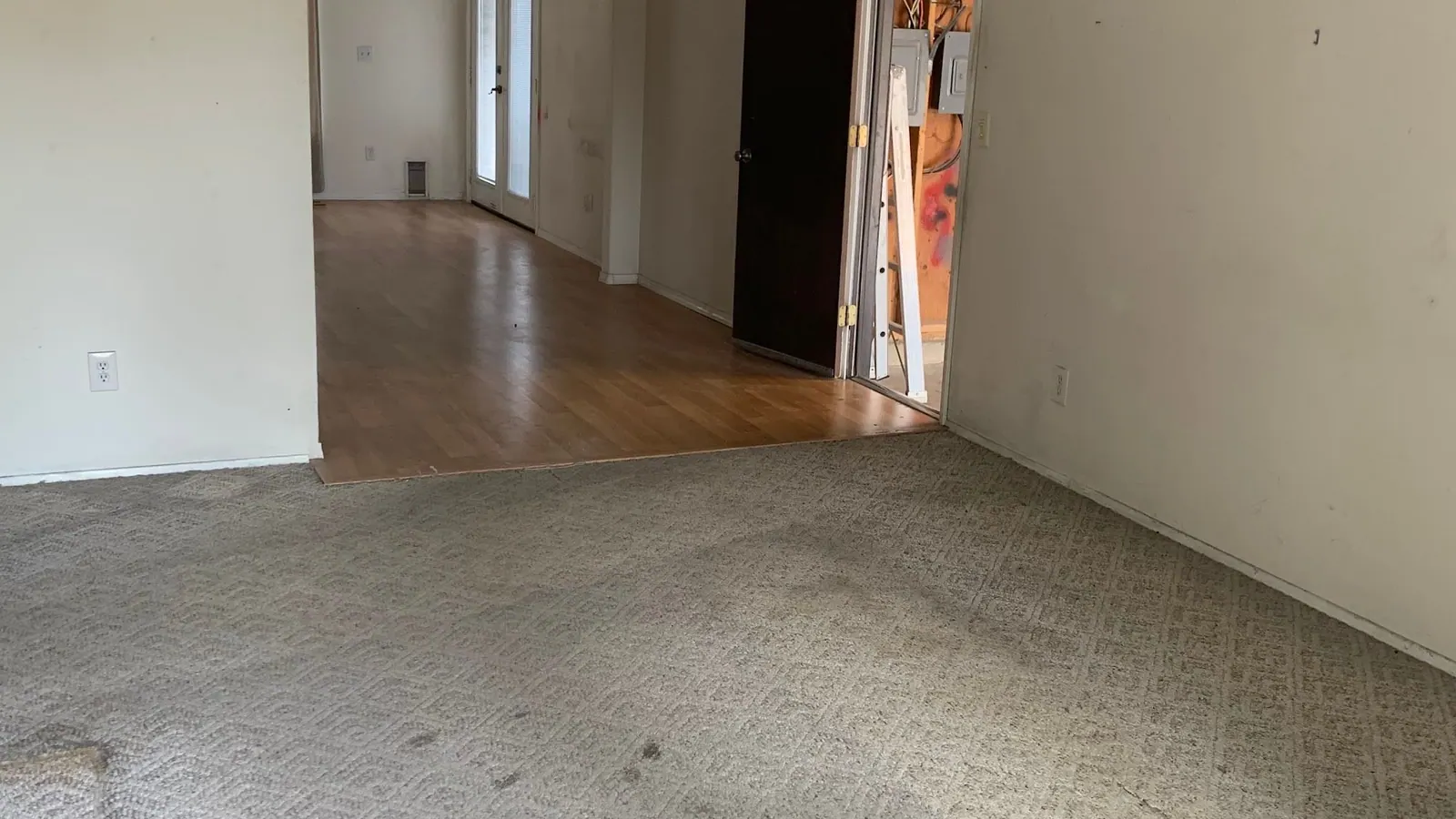 An empty room with carpet and a ceiling light