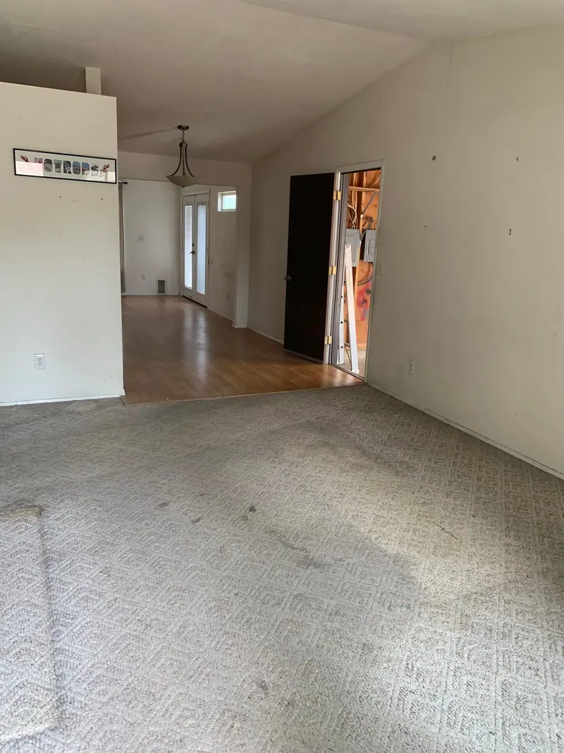 An empty room with carpet and a ceiling light