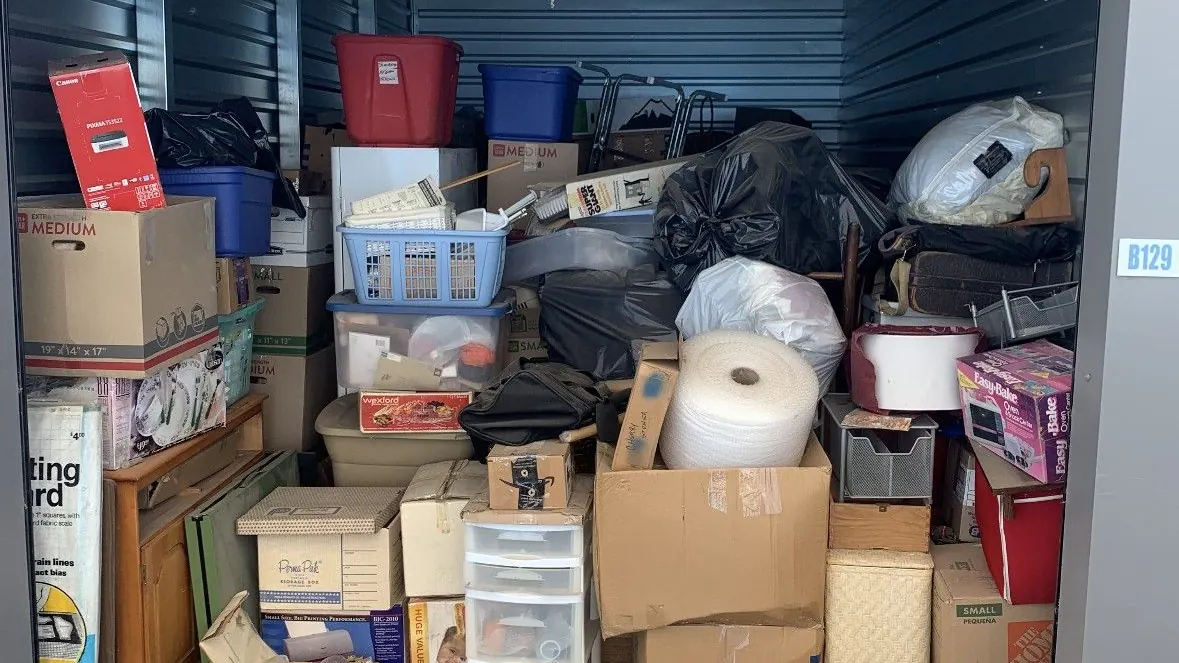 An open storage unit packed with boxes and bins and totes
