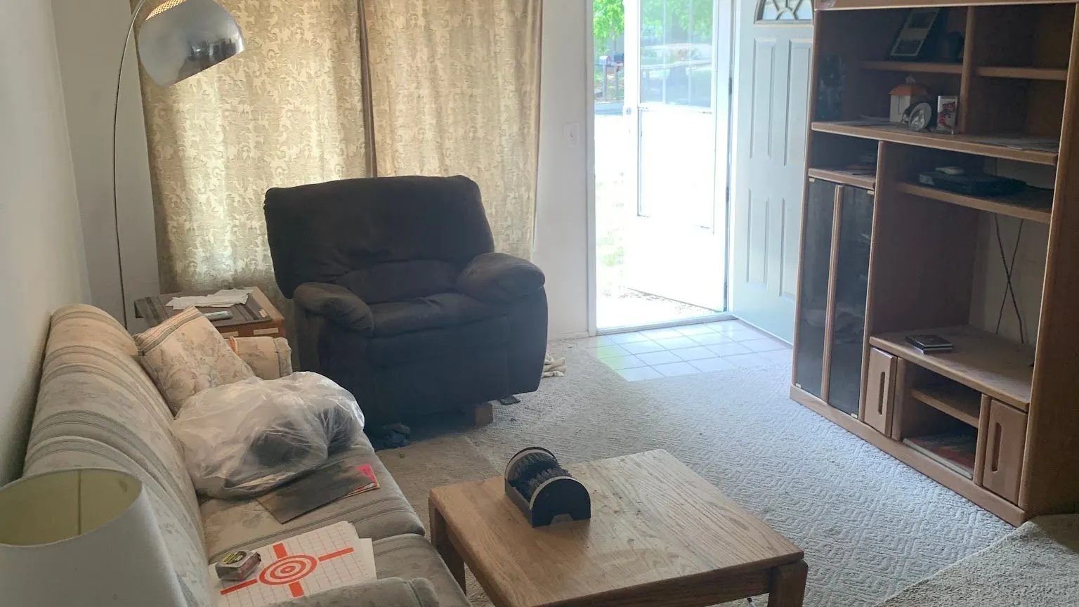 A living room with a striped sofa, a recliner and a coffee table