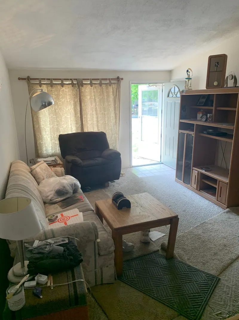 A living room with a striped sofa, a recliner and a coffee table